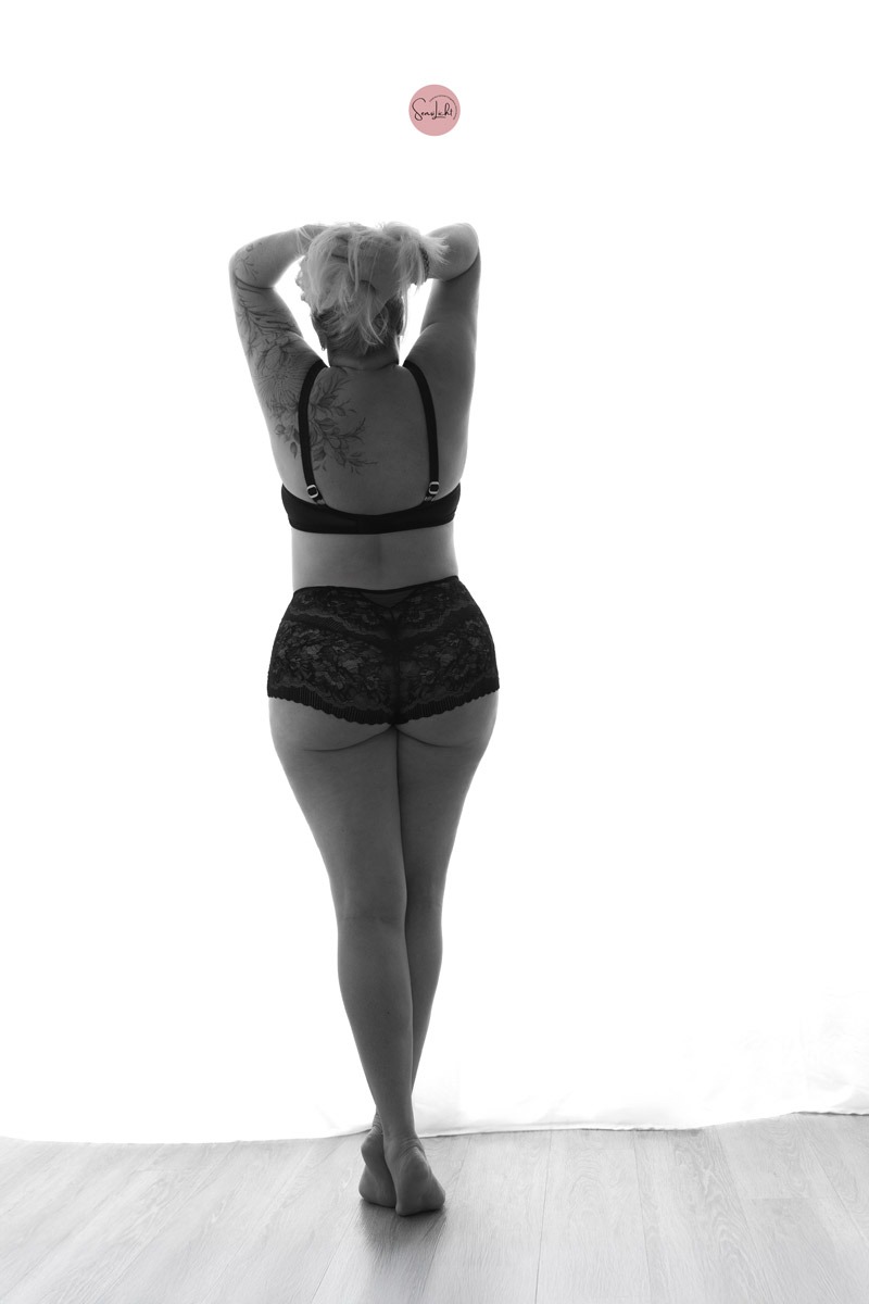 Ästhetisches Plus Size Boudoir Foto in eleganter Unterwäsche vor hellem Hintergrund von SensiLicht Boudoirshooting Hannover